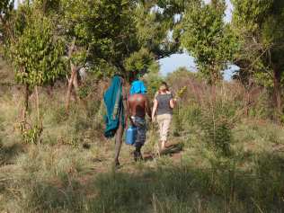 Hiking through the forest to the river with Mursi man
